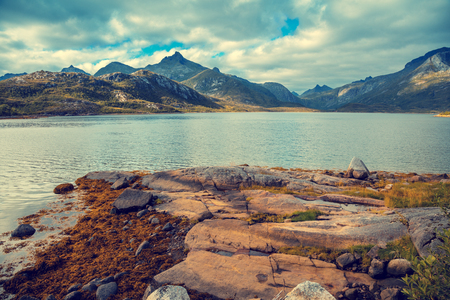 Rocky seashore with cloudy sky. Wilderness. Beautiful nature Norway. Lofoten islands. Reineの写真素材