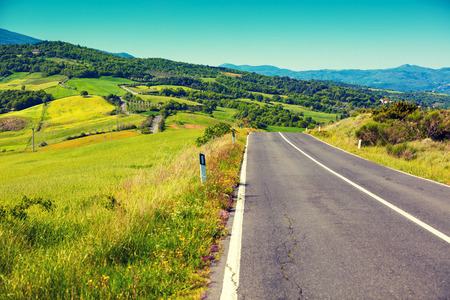 Road among grassed fields. Tuscany landscape. Picturesque countrysideの写真素材