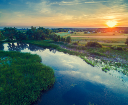 Aerial view of countryside and river in evening.  Sunset over the riverの写真素材