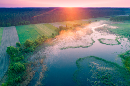 Early misty morning, wilderness. Aerial view of countryside and riverの写真素材