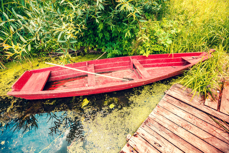 Wooden boat on the river bank at the wooden pierの写真素材