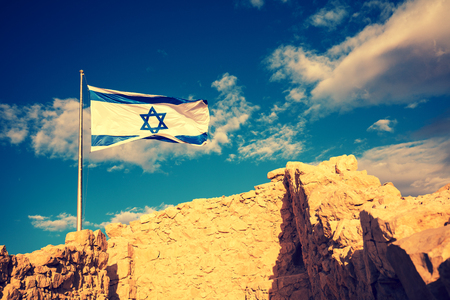 Flag of Israel against the morning sky. The Israeli flag on Masadaの写真素材