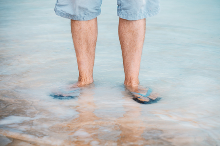 A man walks barefoot on the salty beach of the Dead Seaの写真素材
