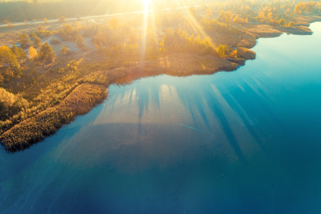 Beautiful aerial view at the island with colorful trees in autumn. Picturesque coastline at sunsetの写真素材