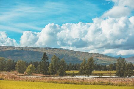 Beautiful mountain landscape with cloudy sky, river, and railway. Norway, Europeの写真素材