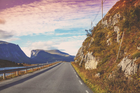 The road along the fjord. The road between the fjord and the mountain at sunset. Beautiful nature of...