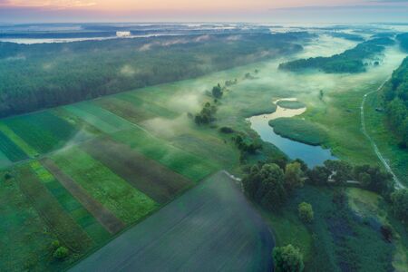 Early misty morning, sunrise over the lake. Rural landscape in summer. Aerial viewの写真素材