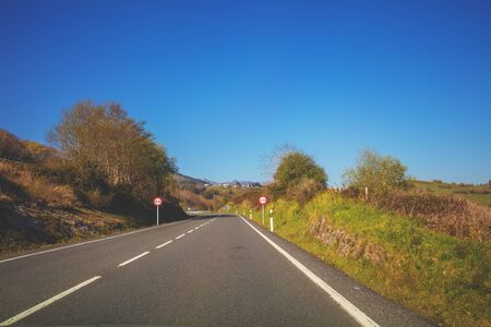 Landscape of asphalt road, hills with trees and clear blue sky. Spain, Europe.の写真素材