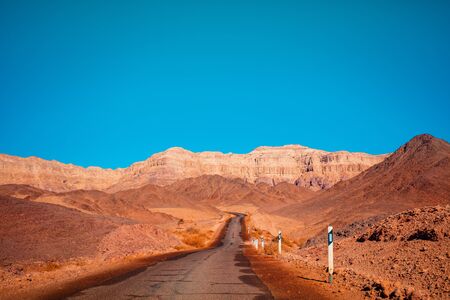 Driving a car on a mountain road in the desert. View of sandstone mountains through the windscreen. Timna Park, Israelの写真素材
