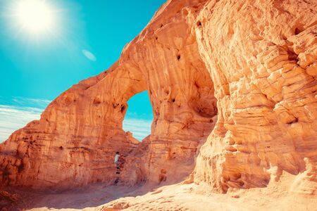 Arch in the rock. A man climbs on a rock. Desert natural landscape. Timna Park. Israelの写真素材