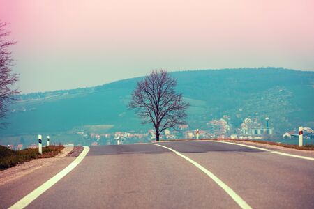 Driving a car on a mountain road. Empty road in the morning in spring. View from a car of the mountain landscapeの写真素材