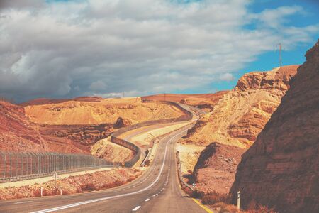 Driving a car on mountain Israel road. Desert landscape. Empty road. The road runs along the border of Israel with Egypt. View from the car of the mountain landscape on a sunny day. Israelの写真素材