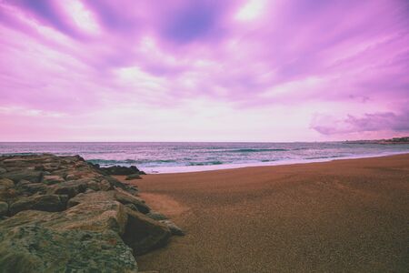 Seascape in the evening. Sunset on the beach.  Sandy rocky seashore with cloudy skyの写真素材