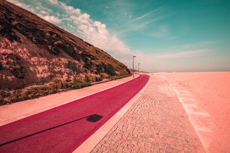 Red promenade on the beach in spring. Beautiful bay on a sunny day. Douro Cabedelo Beach. Porto, Portugalの写真素材