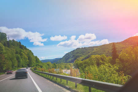 Driving a car on mountain road. Journey by car. View from windscreen of mountain landscape. Carpathian mountains, Ukraine, Europeの写真素材