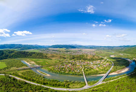 Panoramic aerial view of the mountains, river, and village in the valley in spring. Skyline, beautiful nature landscape. Carpathian mountains. Ukraineの写真素材