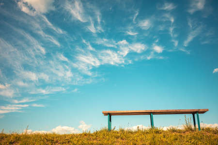 Bench against blue sky with light clouds. Bottom viewの写真素材