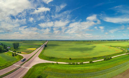 Summer rural landscape, aerial view. View of green fields, forest, village and highwayの写真素材