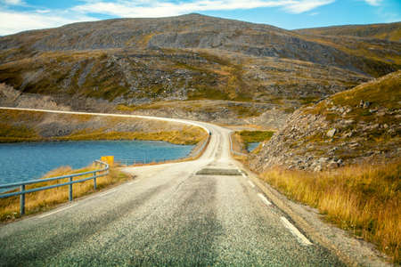 Driving a car on road in tundra. Nature of Norway. Polar circle. The way to Nordkappの写真素材