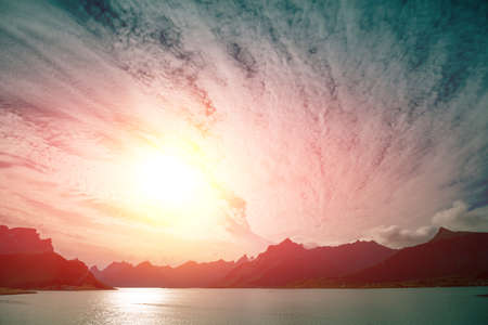 Fjord at sunset with dramatic sky. Rocky seashore in the evening.  Beautiful nature of Norway. Picturesque Scandinavian landscape. Lofoten islands, Norway, Europeの写真素材