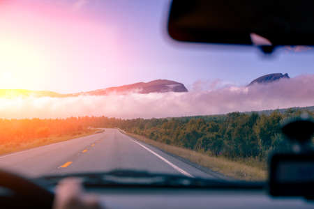 Road to the mountains at sunset. View from the windscreen. Beautiful nature of Norwayの写真素材