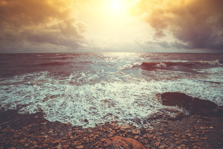 Seascape. Stormy sea at dramatic sunset. Landscape with ocean and bright evening cloudy sky