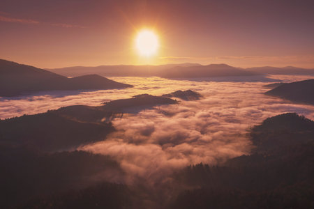 Autumn in the mountains. View of the peaks of mountains and foggy valley during sunset. Beautiful nature landscape. Carpathian mountains. Zakarpattia Oblast, Ukraineの写真素材