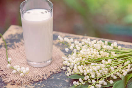 Glass of milk on grunge wooden table outdoorsの写真素材