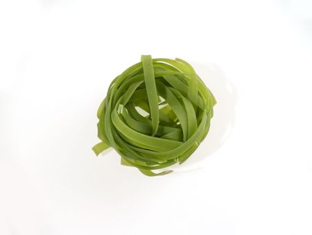 One green pasta nest at white backgroundの写真素材