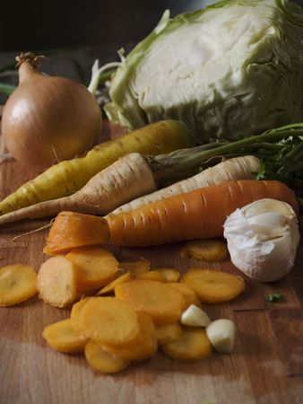 Carrots, onion, garlic and cabbage at cutting boardの写真素材