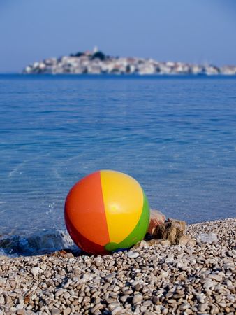 Beach ball, sea and old town at the backgroundの写真素材