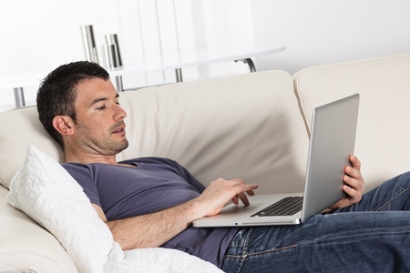 man using computer on sofa at homeの写真素材