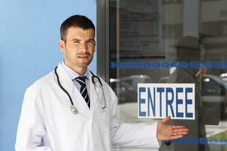 young doctor in front of hospital entryの写真素材