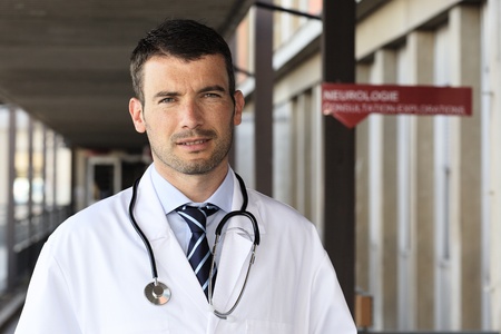 young doctor with stethoscope in hospital hallの写真素材
