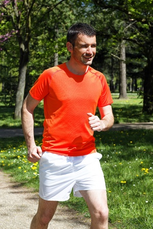 young man running in a park in springの写真素材