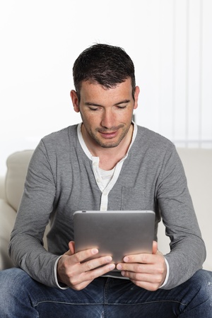 young man on sofa with a digital tabletの写真素材