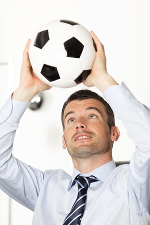 young businessman in office with ball in the handsの写真素材
