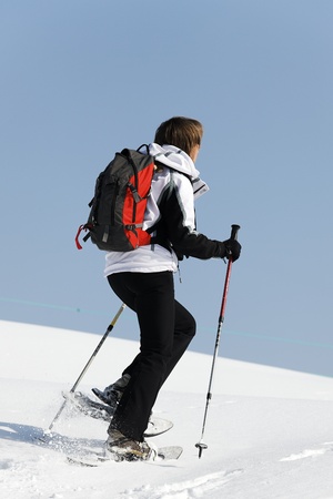 woman walking on the sow with racketsの写真素材