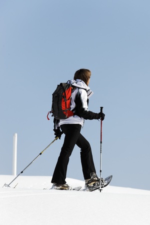 woman walking on the sow with racketsの写真素材