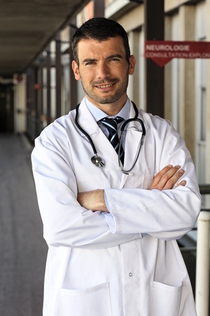 young doctor in front of hospital entryの写真素材