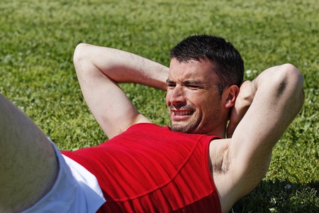 Man make abs exercise in a parkの写真素材