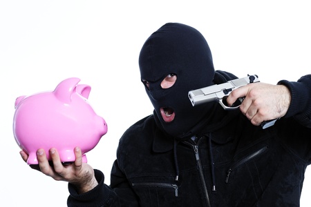 man with a gun and piggy bank in studioの写真素材