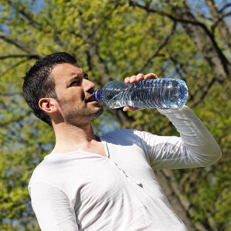 man drinking water after sport in a parkの写真素材
