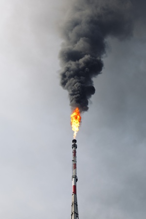 refinery flame and black smoke in the skyの写真素材
