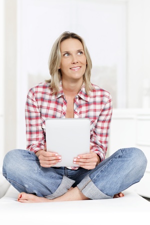 beautiful blond woman on sofa with tabletの写真素材