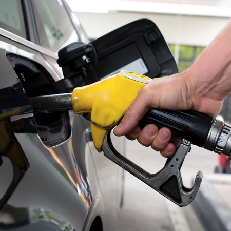 pumping gasoline on a black car in stationの写真素材