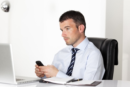 man in office with laptop sending a message の写真素材