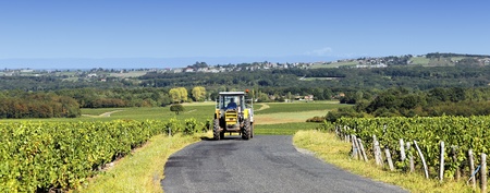 tractor with trailer on the road in autumnの写真素材
