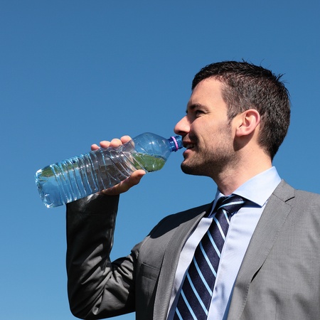 handsome businessmanman drinking water in blue skyの写真素材