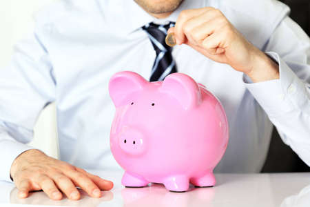 businessman with coin and pink piggy bankの写真素材